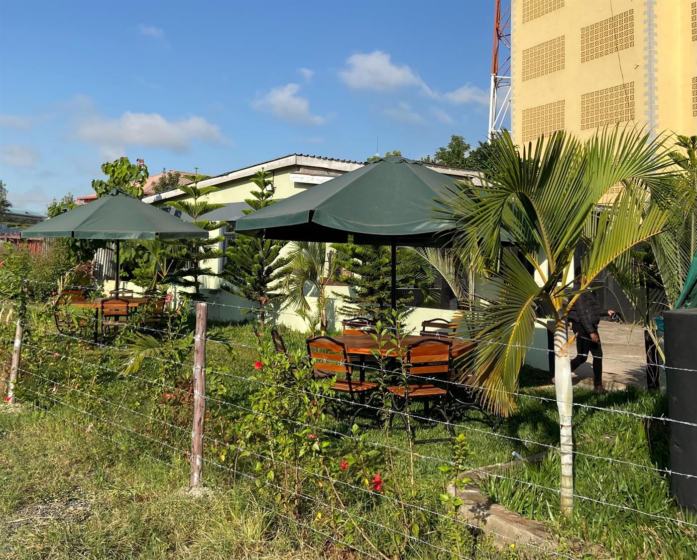 Outdoor seating area with green umbrellas at Lemara Gardens Embakasi